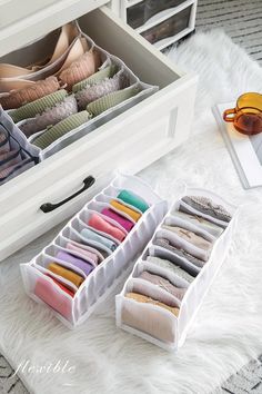 an open drawer with several pairs of shoes and other items on the floor next to it