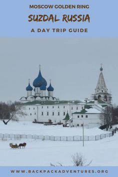 a white building with blue domes in the snow