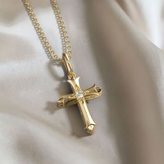 The Fleur-de-Lis Ichthys Cross Pendant Necklace is an exquisite fusion of heraldic grace and spiritual symbolism. This piece features the iconic cross, each arm terminating in the elegant fleur-de-lis, a motif that has symbolized purity and light throughout the ages. At the intersection of the cross, the Ichthys pattern weaves a discreet yet profound layer of meaning, connecting the wearer with an ancient emblem of faith.Centered at the heart of the cross is a luminous stone, catching the eye an Golden Cross Necklace, Golden Cross, Waxing Poetic, Cross Jewelry, Cross Pendant Necklace, Silver Cross, Gold Pendant Necklace, The Cross, Cross Pendant