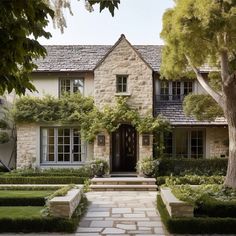 a house with stone steps leading up to the front door and trees in front of it