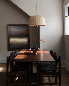 a dining room table with chairs and a vase on it