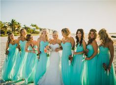 a group of women standing next to each other on a beach