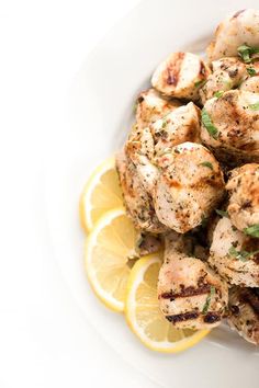 a white plate topped with chicken and lemon slices