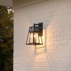 a light that is on the side of a building with trees in the back ground