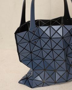 Prism tote bag by Bao Bao Issey Miyake. Matte dark blue triangular tiles adhere to a nylon mesh netting to give this compact tote its geometric form and dynamic structure. Adjustable handles and internal zipped pocket. W 27.5cm x H 27.5cm.Vinyl Chloride, Polyester, Nylon.Made in Japan. Bao Bao Issey Miyake, Bao Bao, Mesh Netting, Geometric Form, Issey Miyake, Made In Japan, Dark Blue, Handles, Mesh