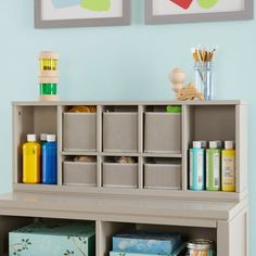 a shelf filled with lots of crafting supplies next to two pictures on the wall