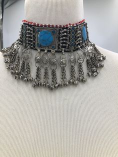 * This rusty silver choker necklace is a heavily embellished yet absolutely elegant piece of craft. The turquoise stones embedded within the necklace, along with the long dangling chain tassels, flaunting all the traditional vibes. This exclusive choker is handmade masterpiece, adorned with metallic weaving technique. You can pair this astonishing article with any trendy outfit, to add a pinch of ethnic touch to your fashion statement. Or compliment your traditional look by pairing it with your Bohemian Silver Beads Choker Necklace, Silver Beaded Turquoise Necklace For Festivals, Bohemian Choker Necklace With Silver Beads, Bohemian Silver Beaded Choker Necklaces, Bohemian Silver Turquoise Necklace For Festivals, Silver Bohemian Turquoise Necklace For Festivals, Silver Choker Necklace For Festival, Turquoise Metal Necklace For Festivals, Traditional Beaded Silver Turquoise Necklace