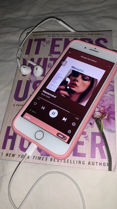 an mp3 player is plugged into the earbuds on top of a magazine