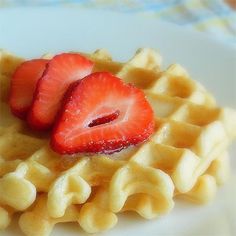 two strawberries are on top of some waffles