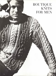 a man wearing a sweater and holding his hands on his head while standing in front of an advertisement for knits for men