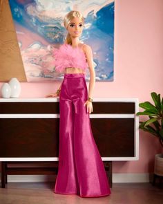 a barbie doll standing in front of a dresser with a pink top and matching pants