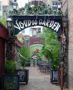 an alleyway with tables and chairs lined up along the side walk that leads to a restaurant