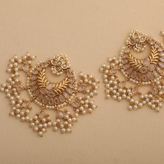 Description: Grab these alluring and exquisite handcrafted chandbali earrings from Tarinika. This set of antique gold-toned traditional chandbali earrings is suitable for all occasions. Studded with dazzling CZ stones and cluster pearl drops, it symbolizes royal elegance. Add this must-have accessory to your collection to pair with ethnic Anarkali's or with a traditional silk saree. Details & Specifications: Materials used: Brass Alloy with Antique Plating Weight – 43 gm Length – 7 cm Make it cu Symbol Of Grace, Traditional Silk Saree, Modern Jewellery, Chandbali Earrings, Ear Rings, Head Accessories, Antique Earrings, Gold Polish, Pearl Drop