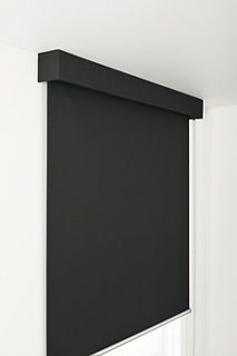 a black roller shade hanging on the side of a wall