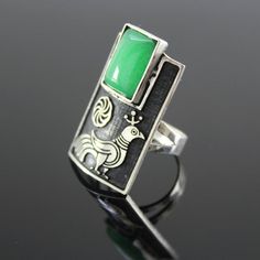 Silver ring with Armenian infinity sign and peacock pattern. The shape is classic, rectangular. She grabs finger very nicely. At the top of the ring is natural chrysolite. The ring is quite large with an interesting design.The ornament is copied from ancient Armenian national drawings.Author's handwork.Ring size - 3,5*2 cm.Ring weight - 10 g. Unique Green Rectangular Rings, Hallmarked Rectangular Emerald Ring, Vintage Rectangular Emerald Ring Gift, Hallmarked Green Rectangular Rings, Hallmarked Green Rectangular Emerald Ring, Unique Green Rectangular Jewelry, Rectangular Green Hallmarked Emerald Ring, Handmade Green Rectangular Ring, Green Modernist Ring As A Gift