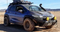 a blue four - doored vehicle is parked in the desert