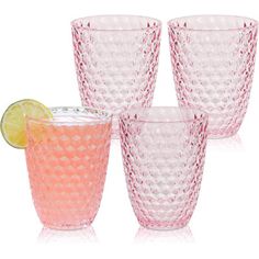 four pink glass cups with lemon wedges and a lime slice on the side, all lined up