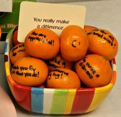 a bowl full of oranges with writing on them and a note that says you really make a difference