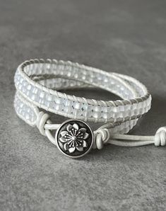 "Made of beautiful beading, this wrap bracelet is designed to wrap 2 times around most wrists. Hand sewn with heavy duty white thread on matching pearlescent white leather cord using frosted white Czech glass seed beads. Closure using an artisan flower antiqued pewter metal button with three loop adjustments for inclusive sizing. Bracelet measures approx. 14 inches and sizing loops adjust approx. 14 1/2\" - 16 1/2\" and fits an average 6 1/2 - 7 inch wrist. **Please message me for custom sizing Handmade Adjustable White Leather Bracelet, White Handmade Adjustable Leather Bracelet, Adjustable Handmade White Leather Bracelet, Handmade White Leather Adjustable Bracelet, Adjustable White Spiritual Wrap Bracelet, White Adjustable Spiritual Wrap Bracelet, Sharp Scissors, Flower Button, Pewter Metal