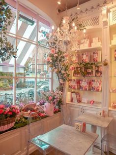 a room filled with lots of flowers and plants next to a large window sill