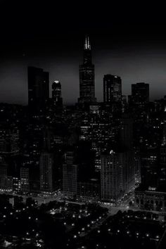 black and white photograph of the city at night with lights in the dark, looking down on skyscrapers