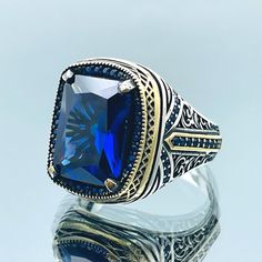 * The centerpiece of this remarkable ring is a square Blue Sapphire stone that exudes elegance and sophistication. The deep blue hue of the stone is both captivating and timeless. * Crafted with precision, this ring is made from high-quality 925k solid silver, ensuring its durability and lasting beauty. * Our Turkish artisans have poured their creativity and passion into every detail of this ring. The intricate design showcases the rich cultural heritage of Turkey, making it a unique and meaningful accessory. * Whether you're shopping for yourself or looking for the perfect gift for a special man in your life, this ring is a thoughtful choice. It's ideal for birthdays, anniversaries, or any occasion that calls for a    memorable present. * Elevate your style and make a statement with our M Luxury Blue Rings With Rectangular Stone, Classic Blue Square Cut Rings, Luxury Blue Square Cut Ring, Luxury Blue Rectangular Stone Rings, Luxury Blue Rectangular Sapphire Ring, Luxury Blue Rectangular Rings, Luxury Blue Signet Ring, Perfect Gift, Luxury Blue Signet Ring As A Gift, Blue Luxury Signet Ring As Gift