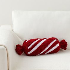 a red and white striped pillow sitting on top of a white couch