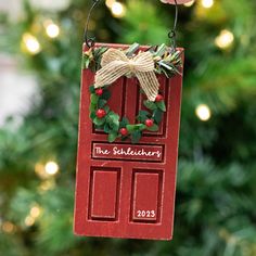 a red door ornament hanging from a christmas tree