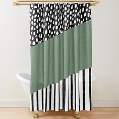 a shower curtain with black and white polka dots on the green strip in front of a bathtub