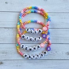 the name ella riley spelled with beads on a white wooden background in pastel colors