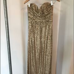 a gold dress hanging on a hanger