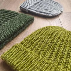 three knitted hats laying on the floor