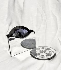 two mirrors sitting on top of a bed next to each other with designs on them