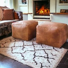 two foot stools sitting on top of a rug in front of a fire place