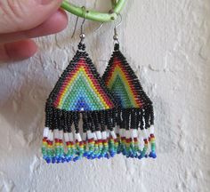 What a fun pair of earrings! Large, triangular seed bead earrings with fringe, in an awesome rainbow pattern. Fringe is rounded at the bottom. Perfect for Pride parades or other LGBTQ+ celebrations or everyday wear. Excellent condition. Beaded Triangle Earrings For Gifts, Triangle Beaded Earrings For Gifts, Adjustable Triangle Beaded Earrings, Unique Handmade Triangle Earrings, Handmade Triangle Earrings For Festival, Beadwork Designs, Rainbow Earrings, Rainbow Pattern, Seed Bead Earrings