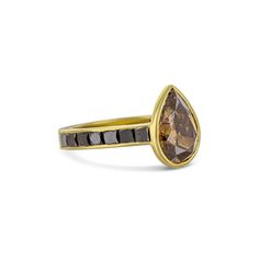 a yellow gold ring with brown and black stones on the band, set in 18k gold