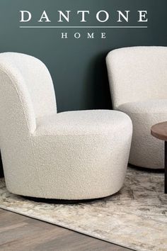 two white chairs sitting on top of a rug next to a table and wall with the words dantone home