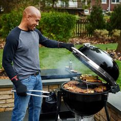 a man grilling food on top of a bbq