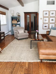 a living room filled with furniture and a wooden flooring area covered in white rugs