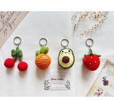 crocheted fruits and vegetables keychains are displayed on a white tablecloth