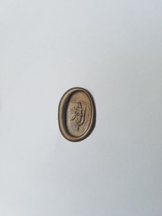 an old button with a man's face on it sitting on a white surface