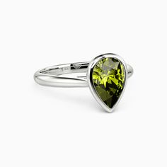 a ring with a green heart shaped stone on the front and side, set in silver