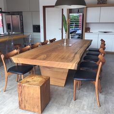 a large wooden table surrounded by black leather chairs