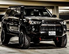 a black toyota truck parked in a parking garage