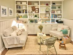 a living room filled with white furniture and lots of bookshelves on the wall