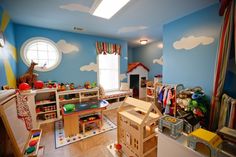 a child's room with blue walls and clouds painted on the wall