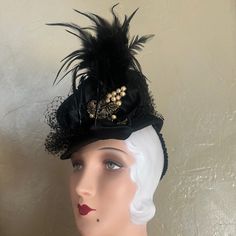 This Is An Adorable Black Felt Tilt Hat From The 1930s'. The Medium Height Crown Is In A Tubular Shape, And The Short Brim Surrounding It, Ends In A Point At The Back. Black Veiling Adorns The Crown, And There Is A Satin Bow At One Side, From Which A Spray Of Black Feathers Emerge. There Is Also A Magnificent Bronze Metal Jewel With Pearls, Which Is Beautifully Preserved For Its Age. There Is Also A Grosgrain Covered Wide Elastic Attached, So As To Hold The Hat In A Tilted Position. Tilt Hats We Vintage Black Fascinator For Party, Black Gatsby Style Fascinator For Evening, Black Gatsby Fascinator For Evening, Vintage Gatsby Style Hat Headpiece, Vintage Black Headpieces For Parties, Gatsby Style Hat For Vintage Events, Black Top Hat For Costume, Black Fitted Top Hat For Costume, Fitted Black Top Hat For Costume