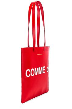 Find COMME DES GARÇONS Logo Tote Bag on Editorialist. This tote bag from COMME des GARCONS is crafted from smooth cow leather. It features a twill lining, double shoulder straps that measure approximately 25 inches in length with a 10 inch drop, and an interior zip pocket. The bag measures approximately 14 inches wide by 13 inches high by 0.25 inches deep. It features a printed logo detail and a gold foil logo detail. Red Leather Handle Shoulder Bag For Business, Red Leather Handles Shoulder Bag For Business, Red Leather-handled Shoulder Bag For Business, Red Calf Leather Shopping Bag, Red Calf Leather Bag For Shopping, Designer Red Calf Leather Bag, Red Bag With Smooth Grain, Red Bags With Smooth Grain, Red Calf Leather Bag With Soft Texture