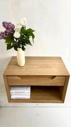 a vase filled with flowers sitting on top of a wooden shelf