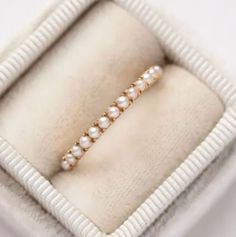 a pearl and diamond ring in a box